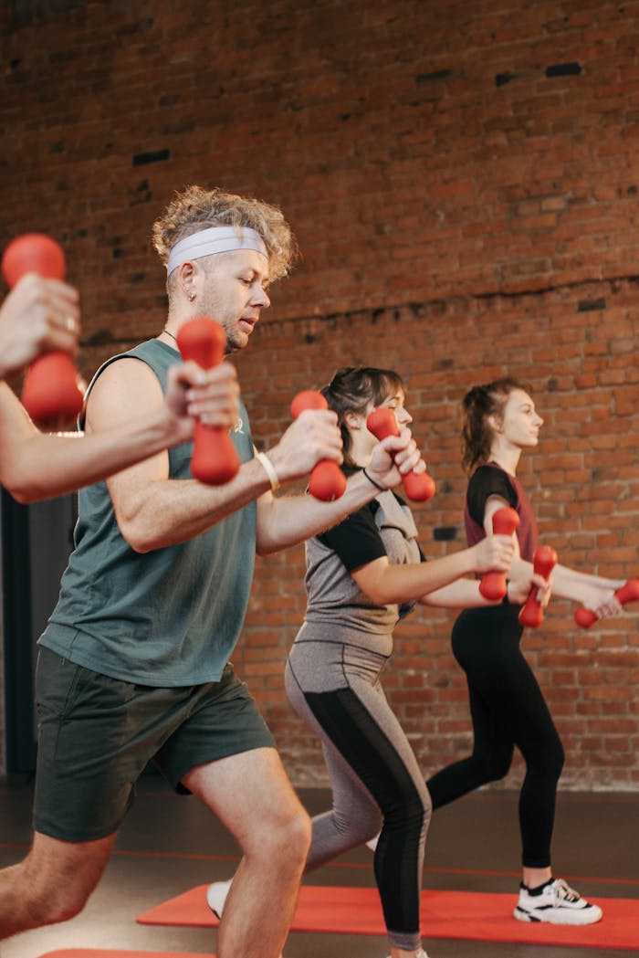 Services Diverse group exercising with dumbbells in an indoor gym setting, promoting healthy lifestyle.